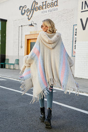 Textured stripe faux fur trim poncho with fringe detail and hood.