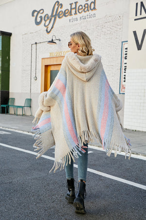 Textured stripe faux fur trim poncho with fringe detail and hood.