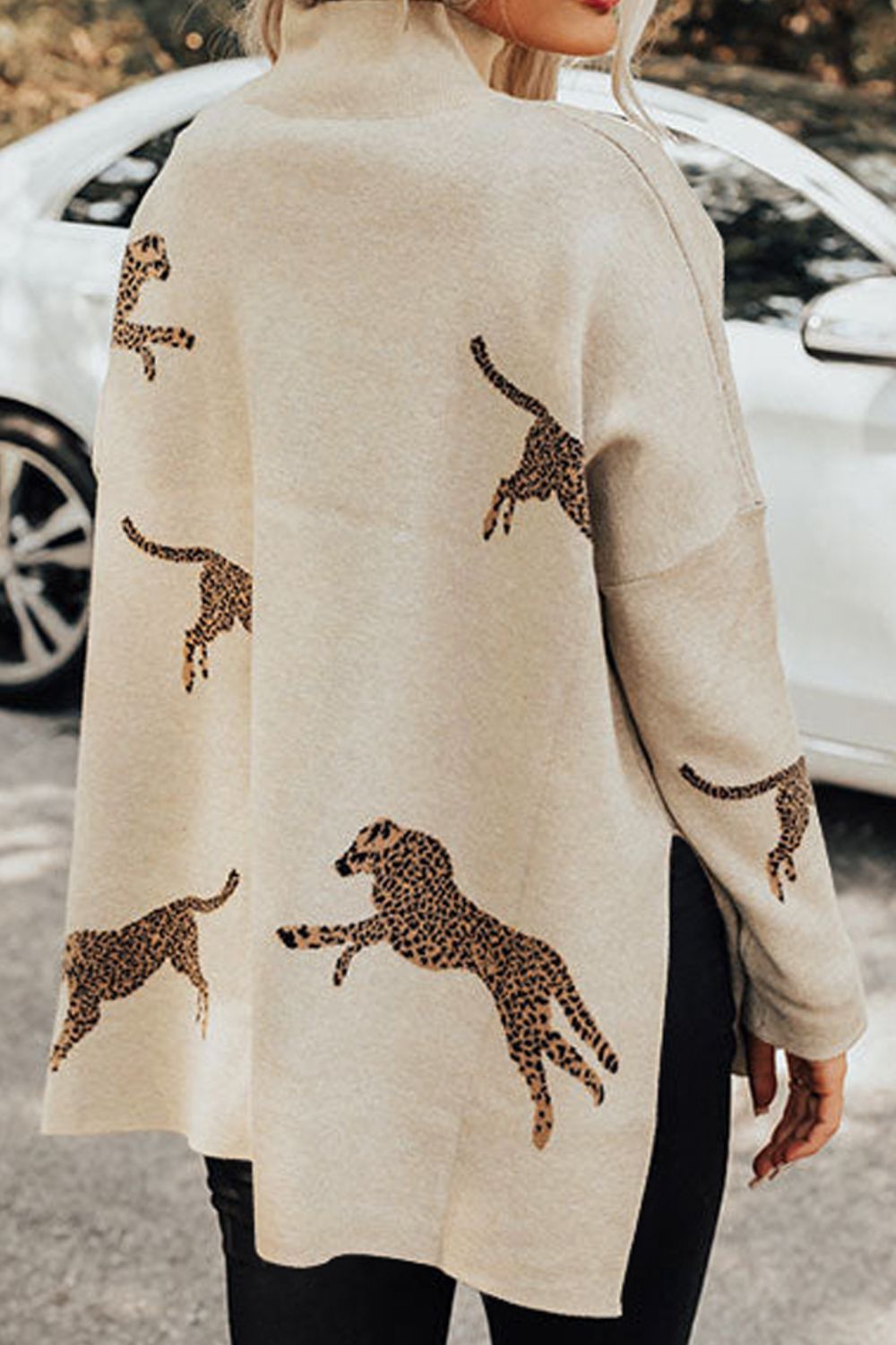 Cream mock neck knit sweater with allover leopard print and side slits.