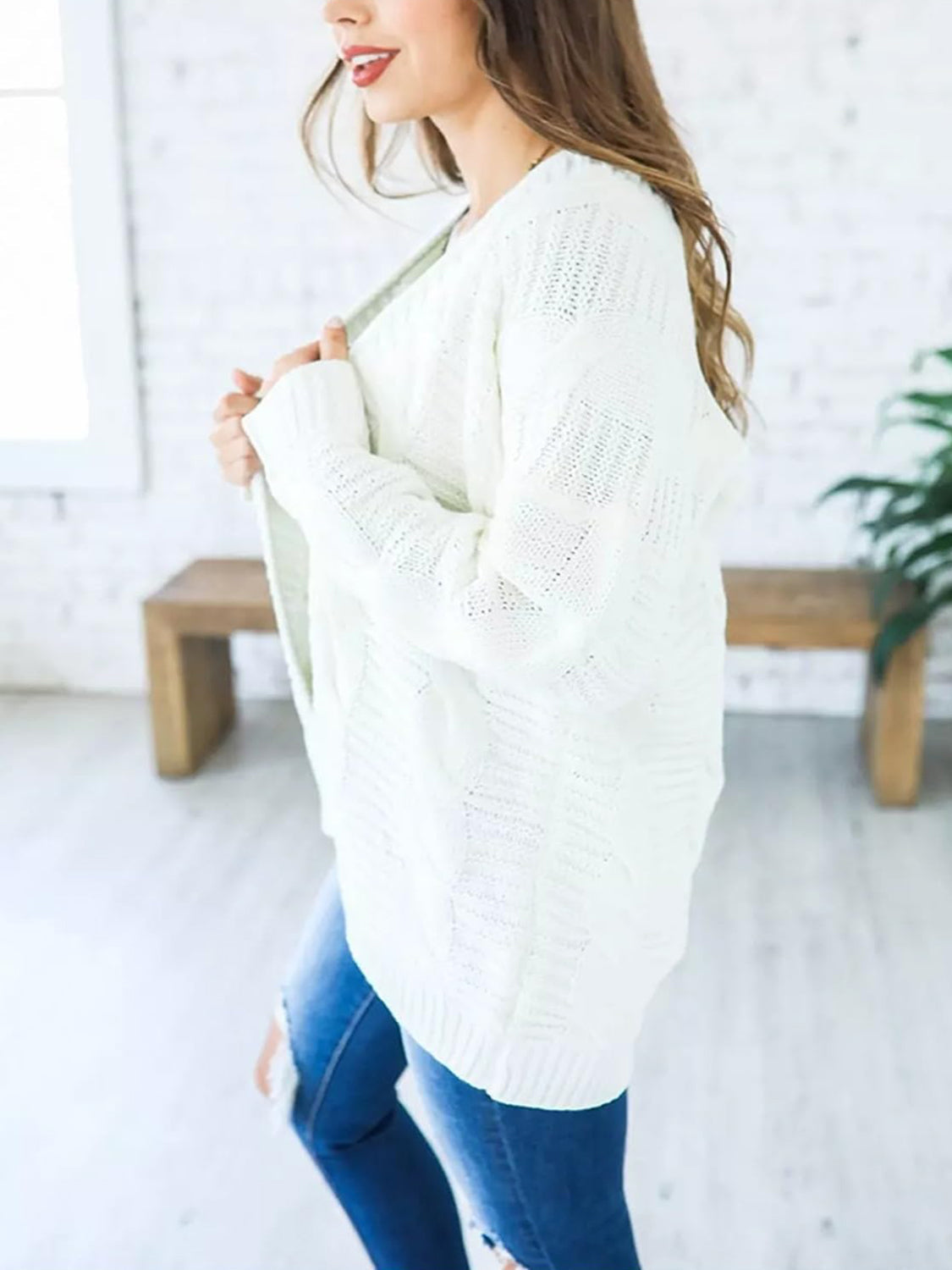White cable knit duster cardigan with textured pattern and open front.