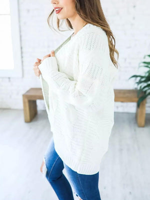 White cable knit duster cardigan with textured pattern and open front.