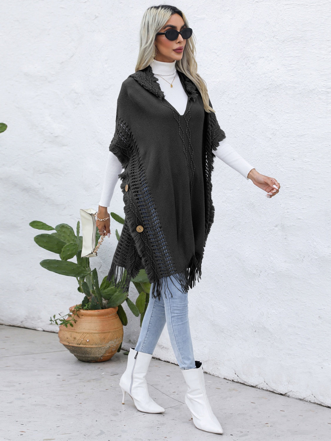 Dark gray textured knit poncho with fringe and wooden buttons, V-neck, open front.