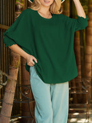 Dark green textured blouse with elastic smocked cuffs and dolman sleeves.