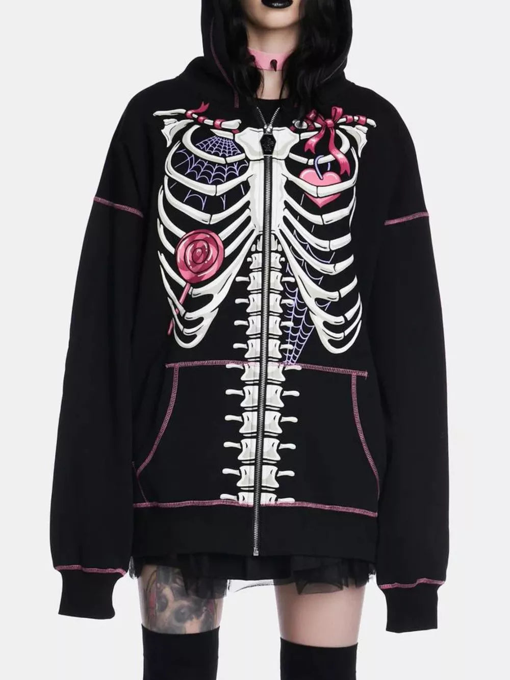 Black zip-up hoodie with playful skeleton graphic, pink stitching, and drawstring hood.