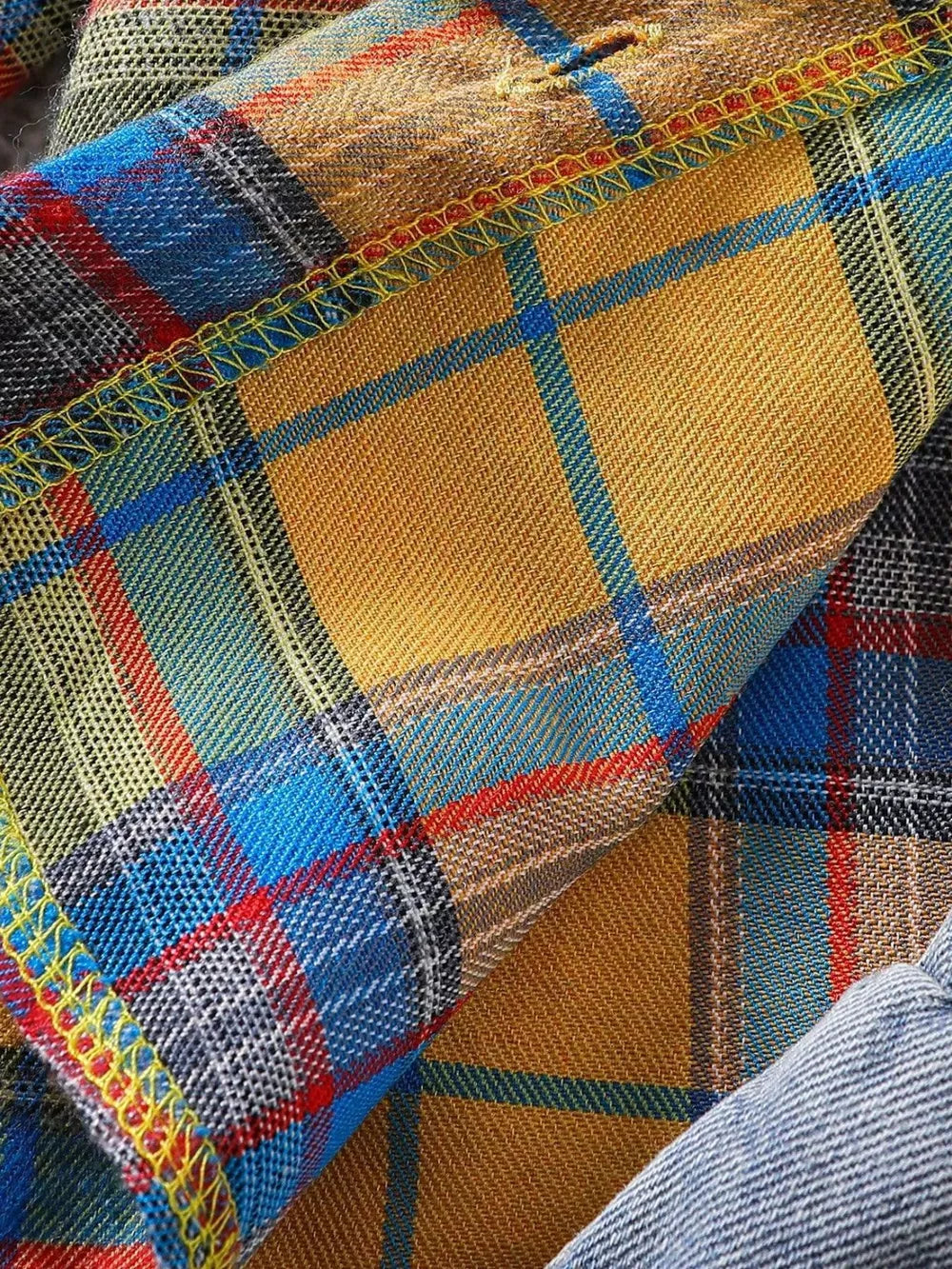 Cotton plaid shirt fabric with yellow, blue, red, and gray plaid pattern and decorative yellow stitching.