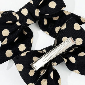 Black polka dot bow barrette with silver clip detail