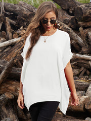 White asymmetrical sleeve blouse with draped hem, styled casually.