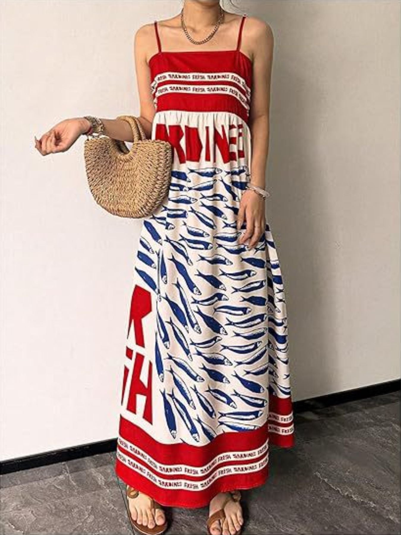 Red and white spaghetti strap maxi dress with blue sardine print and text detail.