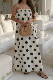 Cream polka dot maxi dress with smocked bodice and spaghetti straps.