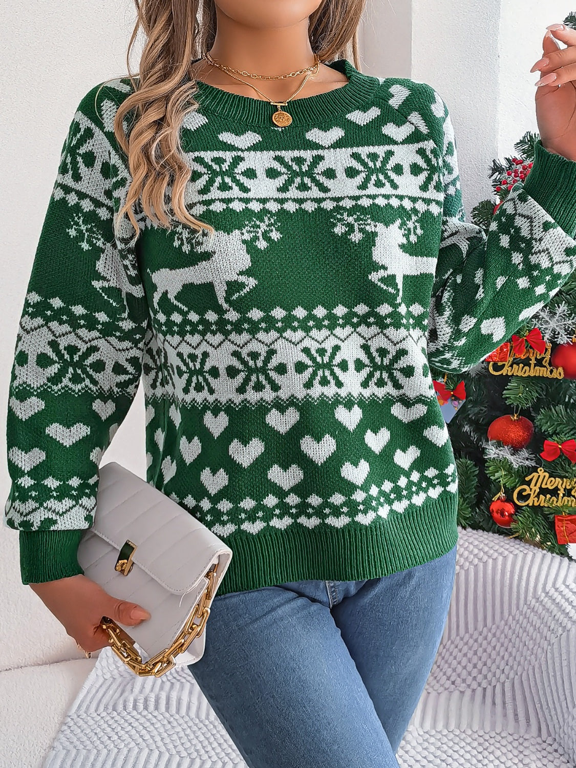 Green acrylic sweater with reindeer, snowflake, and heart jacquard pattern.