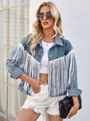 Denim trucker jacket with white fringe trim and rolled sleeves.