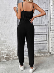 Black chain-strap gathered waist jumpsuit with a belted waist and cuffed ankles.