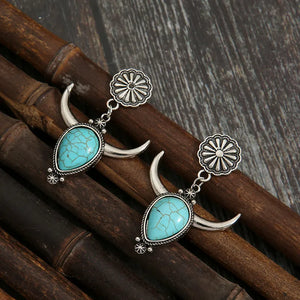 Southwestern crescent drop earrings with turquoise stones and silver alloy.