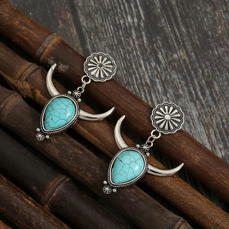 Southwestern crescent drop earrings with turquoise stones and silver alloy.