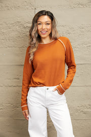 Caramel waffle knit raglan sweater with contrast stitching and ruffled cuffs.