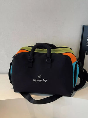 Vibrant duffel bag with black, orange, green, and blue panels and embroidered text.