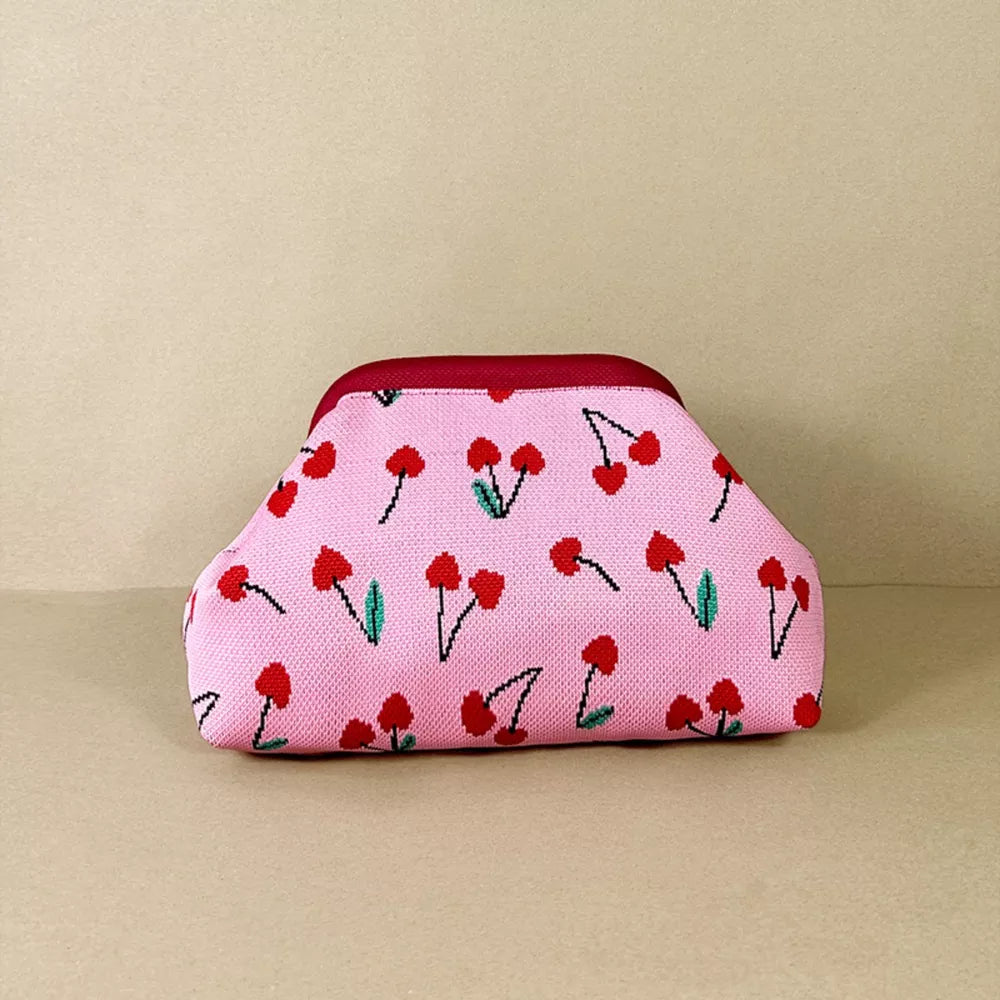 Pink knit clutch with red cherry pattern and maroon trim