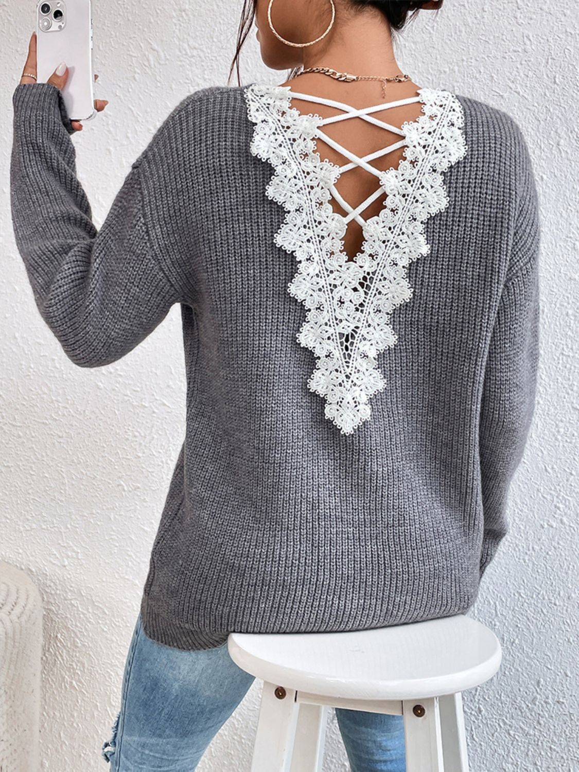 Gray ribbed knit sweater with white lace back detail and criss-cross straps.
