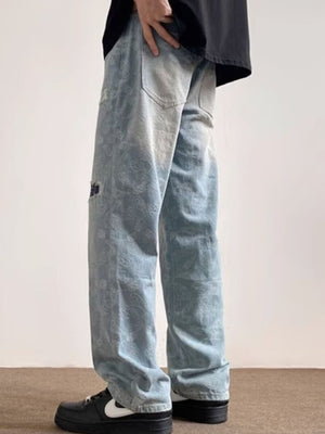 Men's light blue distressed wide-leg jeans with paisley pattern and pocket detail.