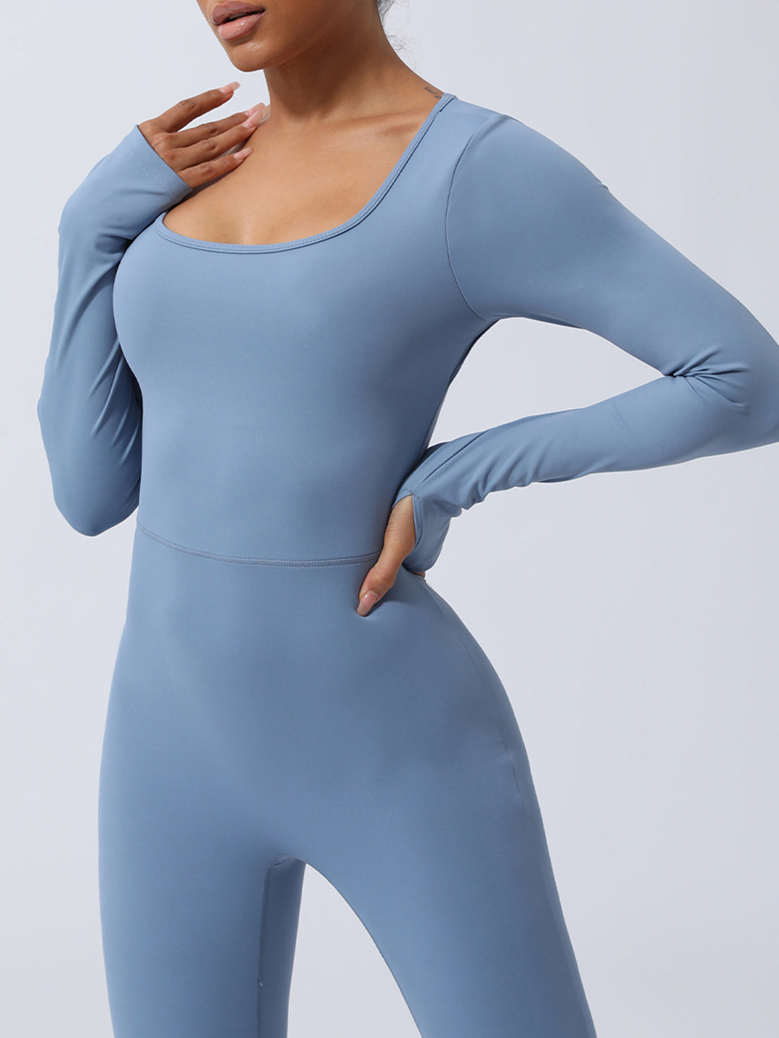 Light blue long sleeve sculpting jumpsuit with thumbholes and a scoop neck.