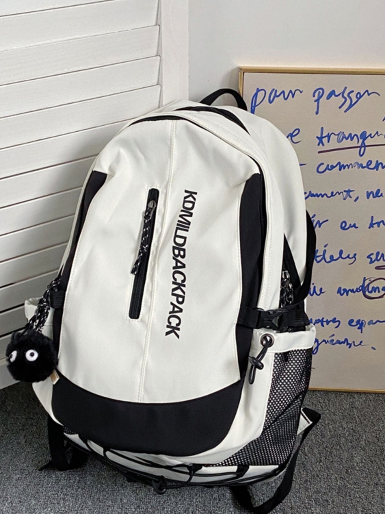 Large white and black nylon backpack with zippered pocket and fuzzy charm