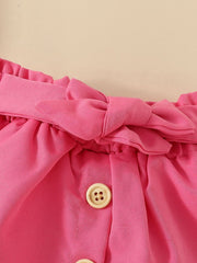 Pink baby set with ruffled waist, bow detail, and wood buttons.
