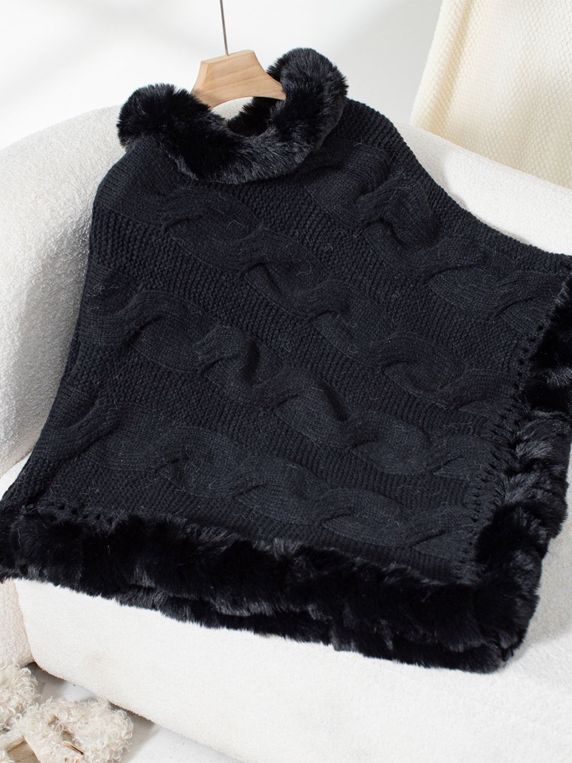 Black cable knit poncho with faux fur trim and collar detail.