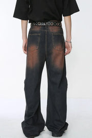 Acid wash flare jeans in dark denim with distressed detailing and stud belt.