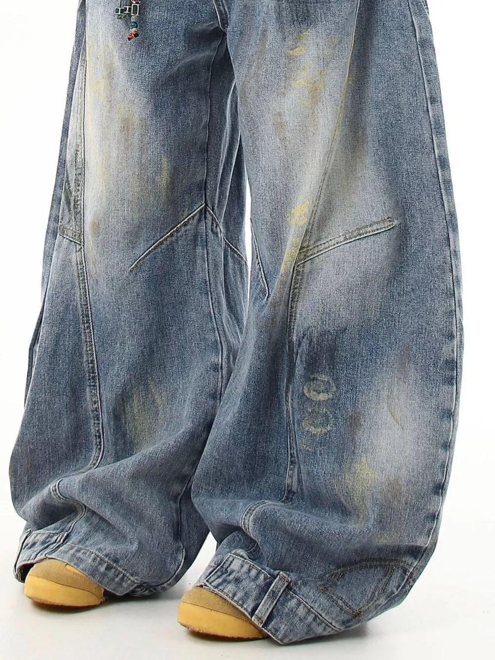 Washed blue wide-leg jeans with pocket detail and distressed accents.
