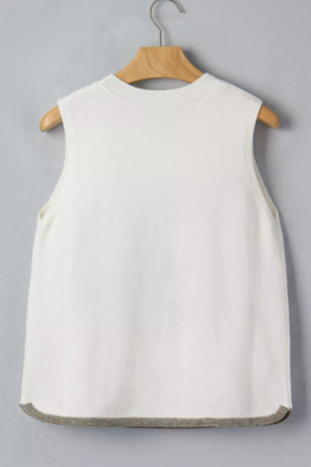 White knit sweater vest with a crew neck and contrast trim hem.