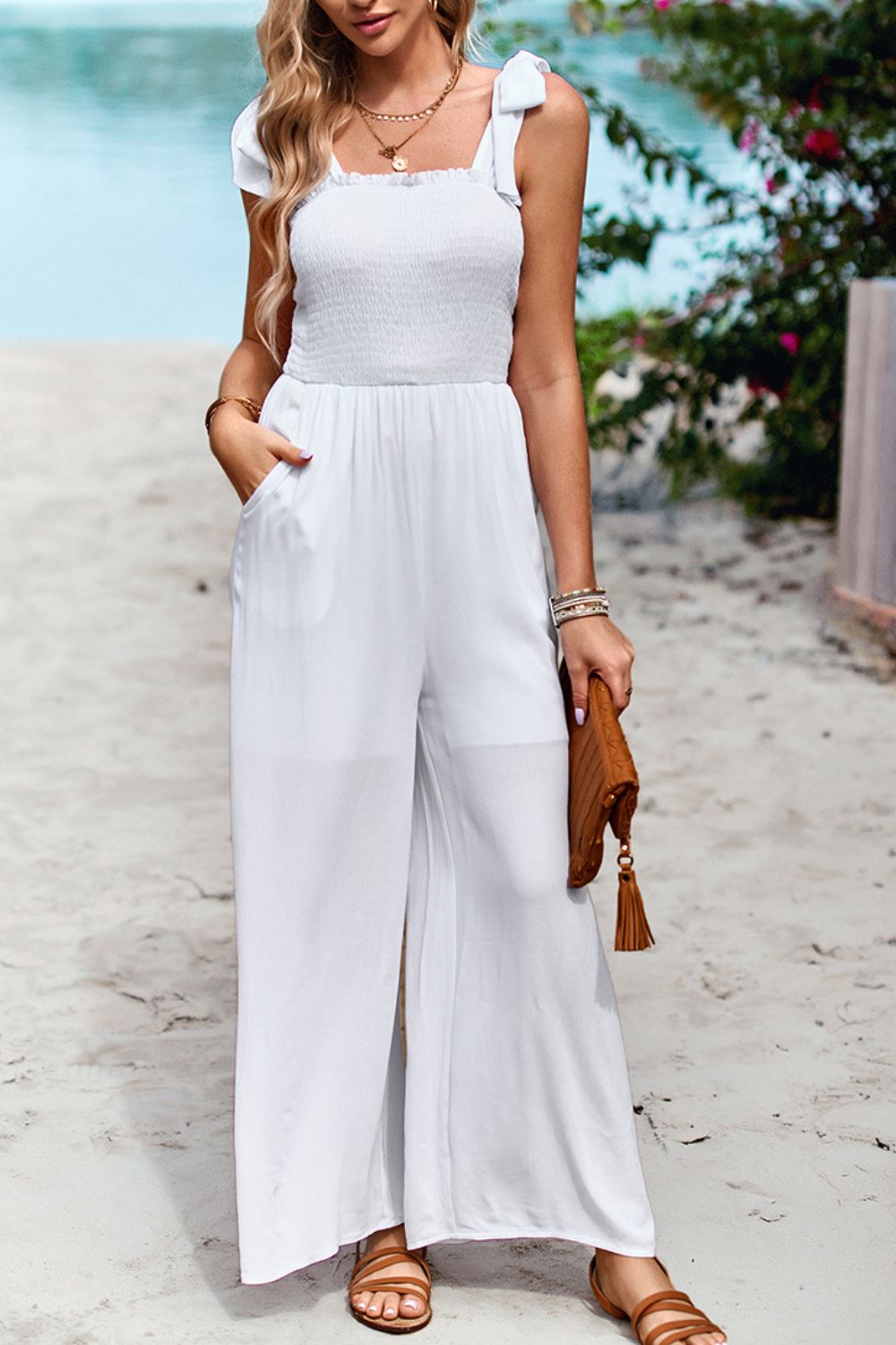White smocked bodice tie-strap palazzo jumpsuit with wide legs and pockets.