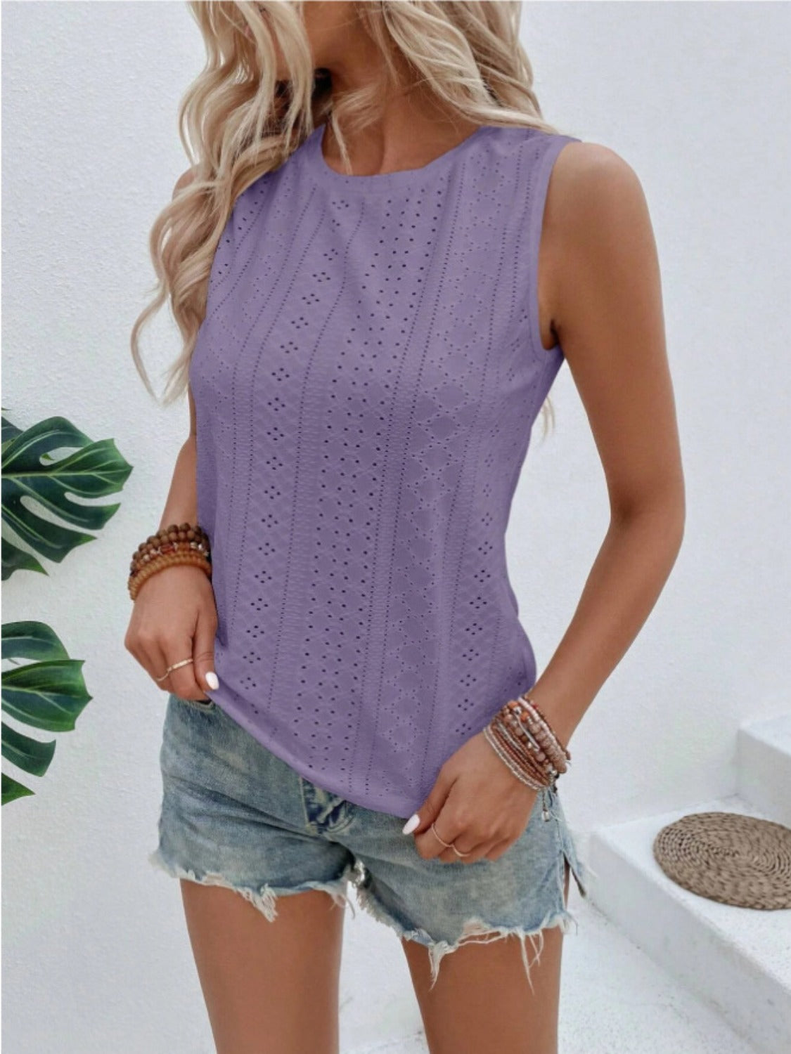 Sleeveless purple eyelet blouse with round neckline and textured pattern.