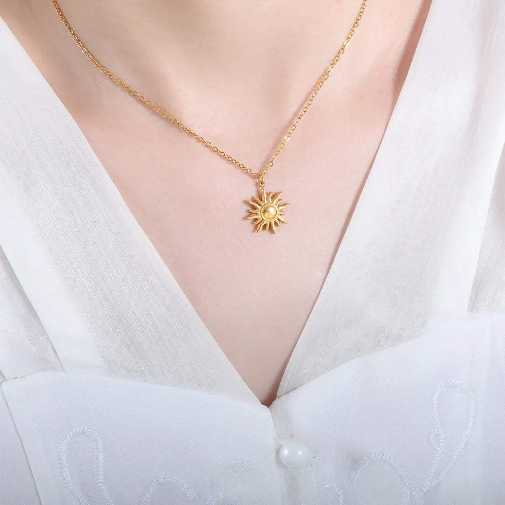 Gold sunburst pendant necklace with adjustable chain, 18K gold-plated.