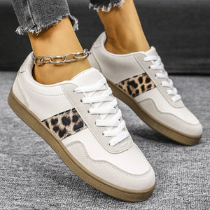 White retro sneakers with leopard print panels and suede accents.