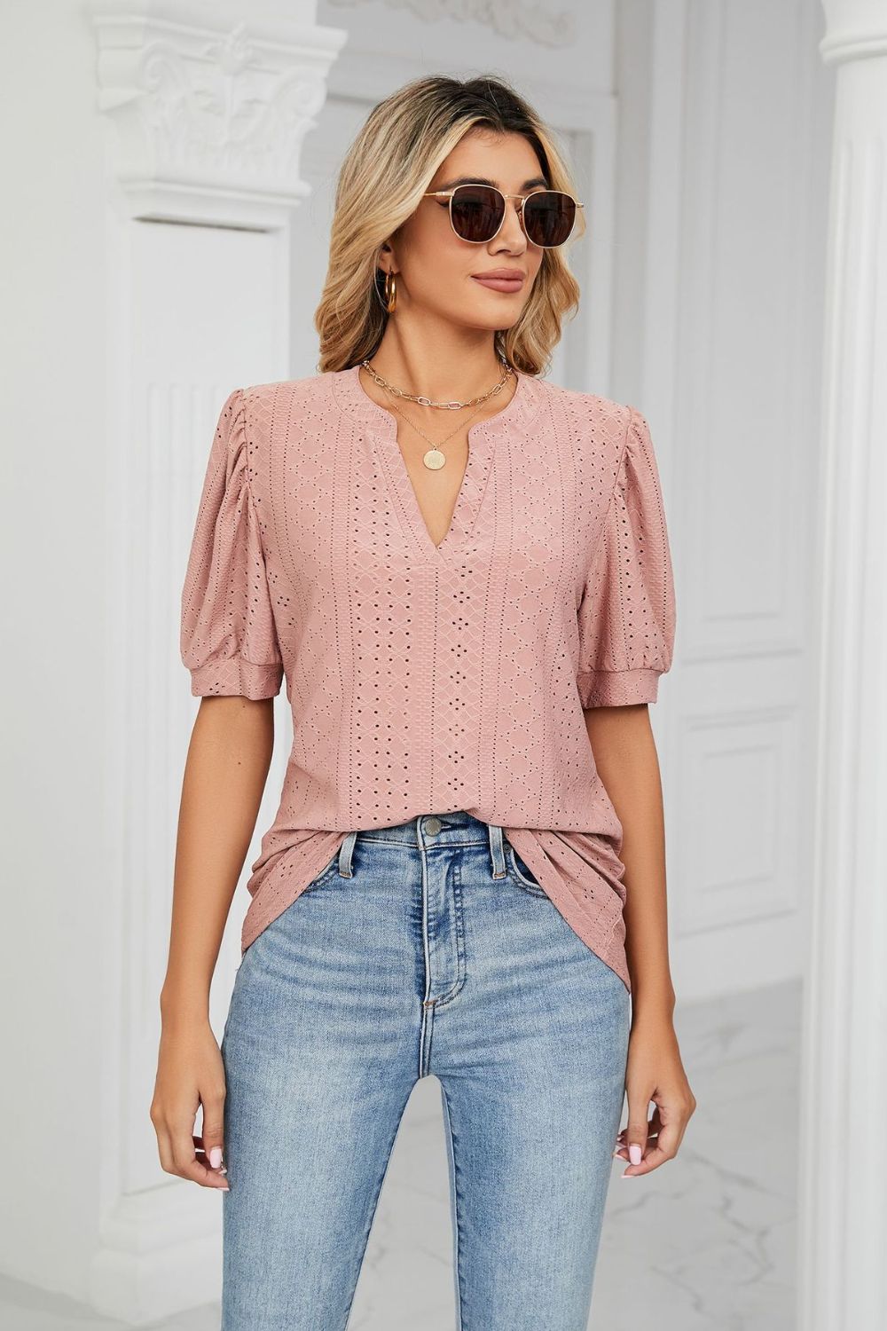 Pink perforated puff sleeve blouse with keyhole neckline and textured pattern.