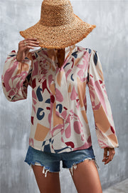 Abstract print pussy bow blouse with balloon sleeves in pink and cream with geometric shapes.
