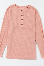 Dusty pink ribbed henley knit top with button detail and relaxed fit.