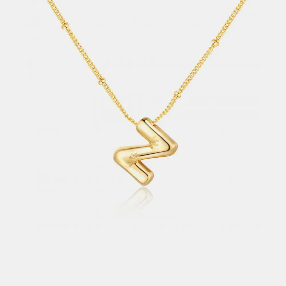 Gold initial pendant necklace with a bubbly letter Z charm and star detail.