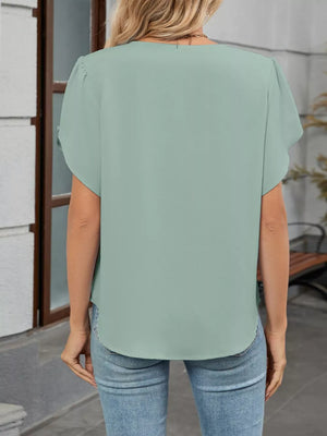 Mint green polyester pleated short sleeve blouse with a rounded hem.