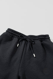 Black textured lounge pants with drawstring waist and silver-tipped ends.