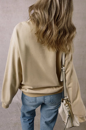 Khaki sweatshirt with pockets and crew neck, worn with blue jeans.