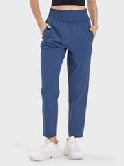 Peacock blue performance trousers with elastic waistband and pockets.