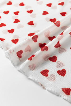 Sheer white t-shirt with red heart print, close-up detail of mesh fabric.
