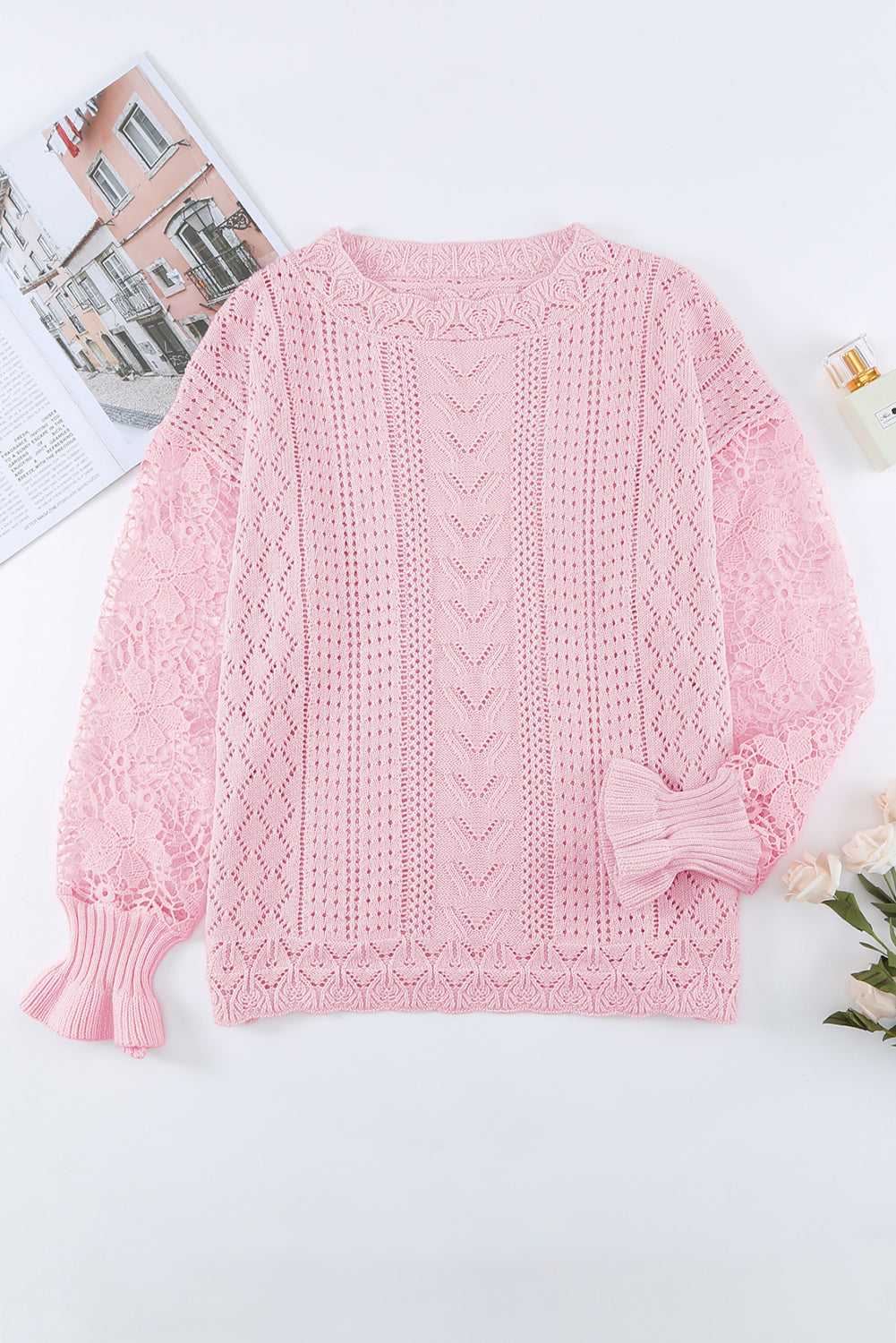 Pink openwork knit sweater with lace sleeves and ruffled cuffs.
