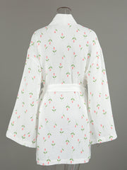 White cotton robe with pink floral print and green leaves, belted waist, kimono sleeves.