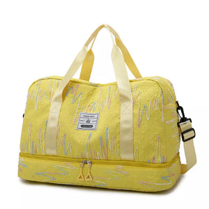 Yellow textured Oxford duffel bag with colorful wave embroidery and dual zip bottom compartment.