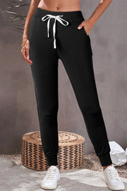 Black slim-fit joggers with white drawstring and cuffed ankles.