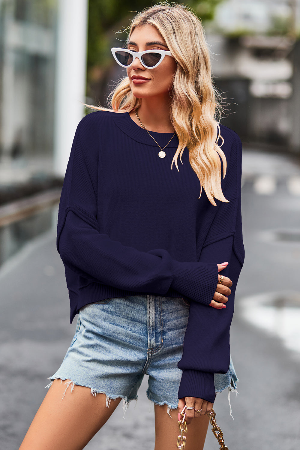 Dark blue ribbed knit batwing sweater with crew neck and cropped length.