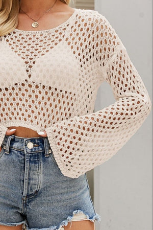 Apricot cropped open knit top with bell sleeves, styled with denim shorts.