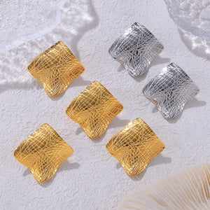 Textured square statement earrings in gold and silver with a crisscross pattern.